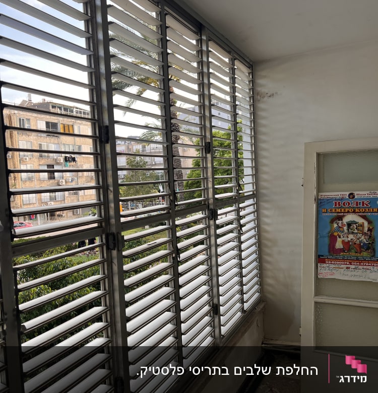 תריסים אופקיים מתכתיים על חלון זכוכית גדול